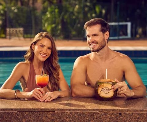 Casal com drinque e água de coco no bar molhado da piscina do Lagos de Jurema